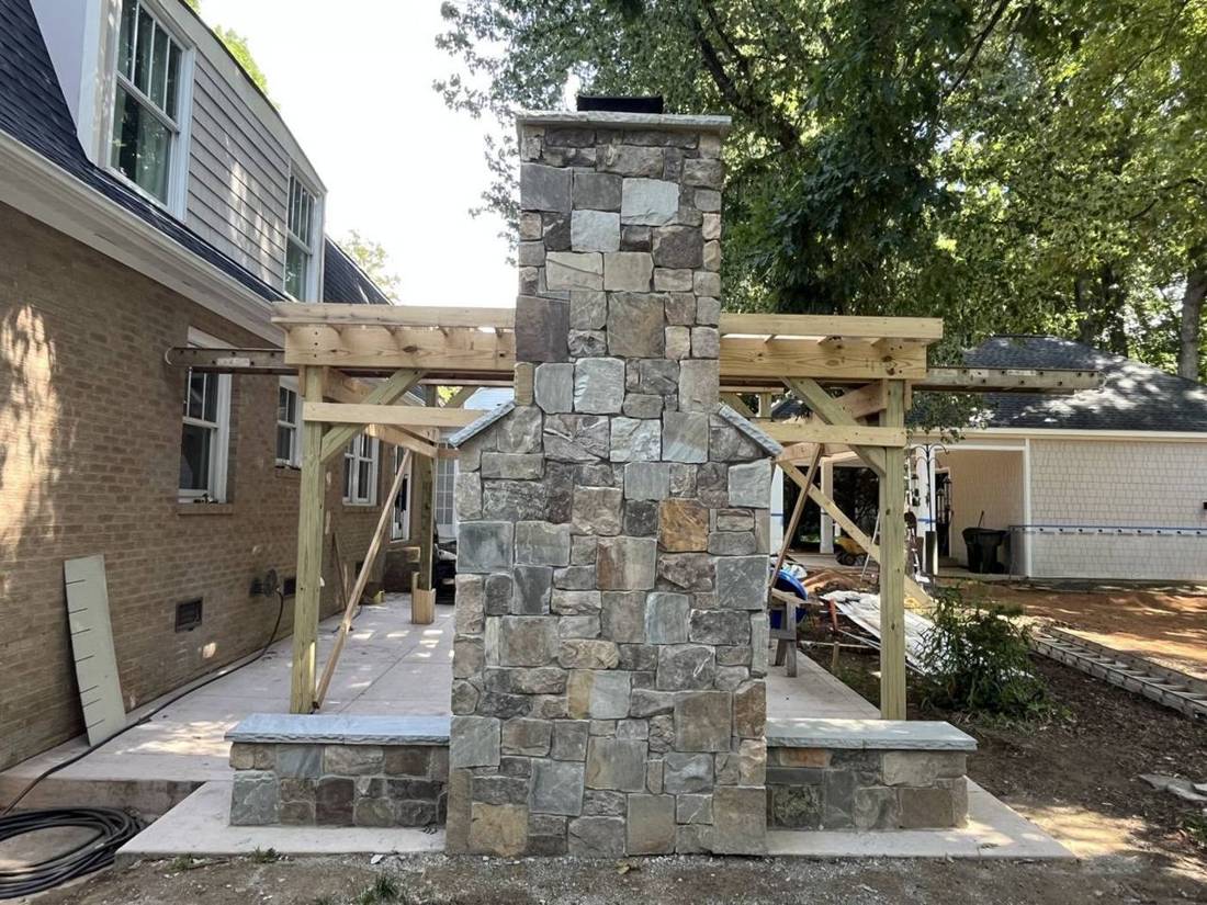 Natural stone chimney with seat walls and new pergola framing