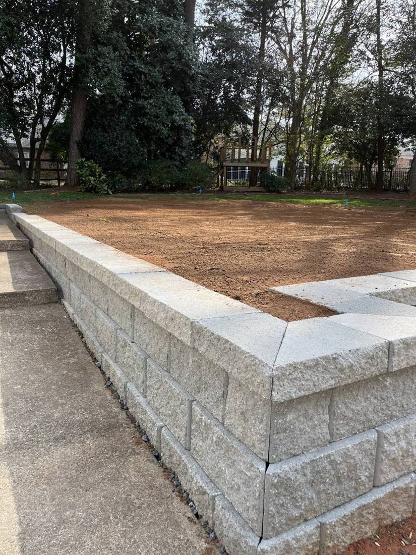 Block retaining wall corner with capstones
