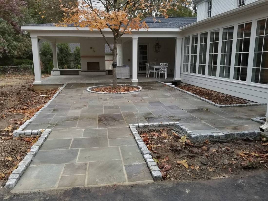 Bluestone courtyard with granite cobble borders and a tree ring