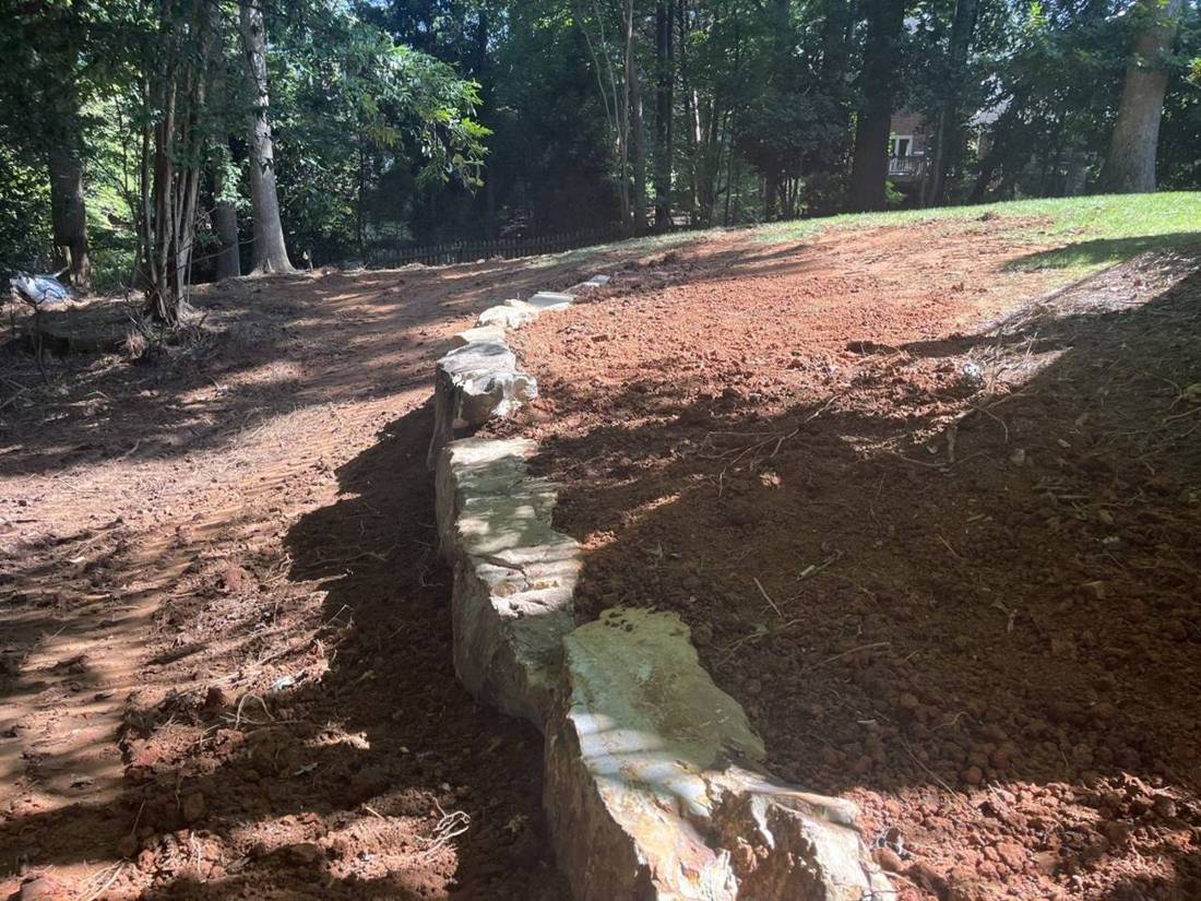 Boulder wall holding a regraded slope
