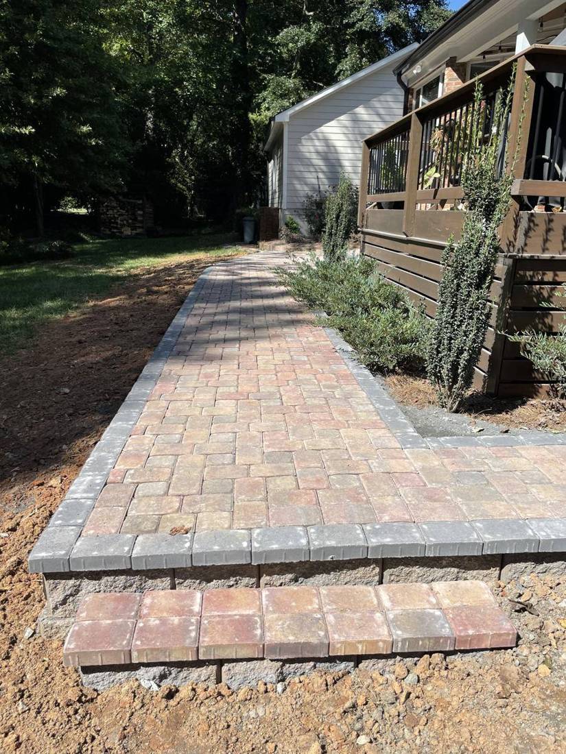 Red-blend paver walkway with charcoal border and a paver step