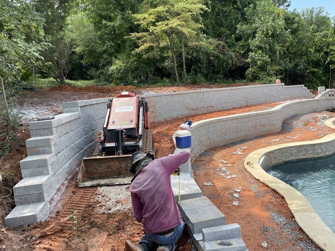 Crew member measuring block steps between two retaining walls