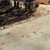 Boulder retaining wall along driveway